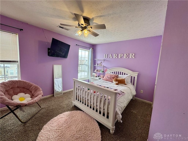 bedroom featuring ceiling fan, a textured ceiling, and dark colored carpet