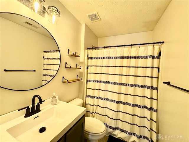 bathroom with a textured ceiling, toilet, and vanity