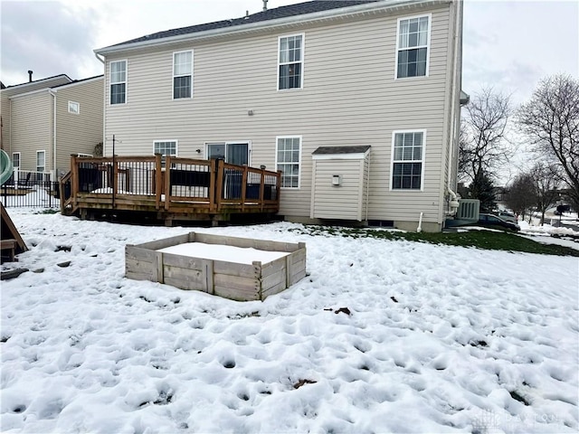 snow covered back of property featuring a deck and central air condition unit