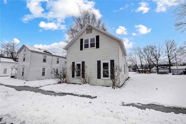 view of snow covered back of property