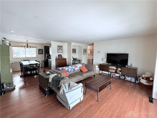 living room with hardwood / wood-style floors and a notable chandelier