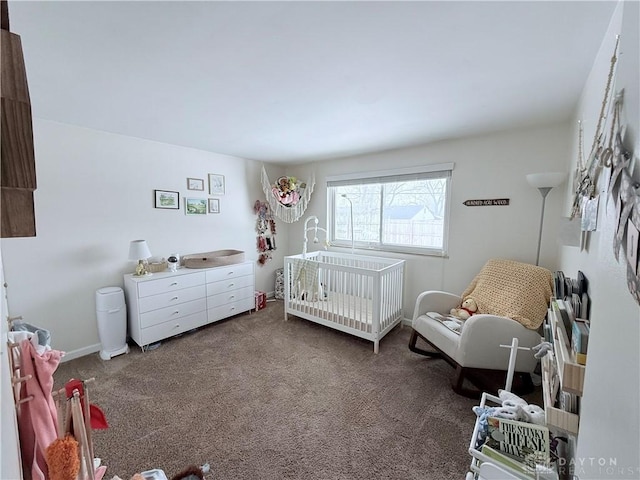 carpeted bedroom featuring a crib and baseboards