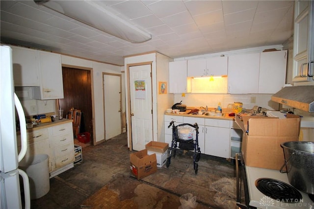 kitchen featuring white refrigerator, white cabinets, and sink