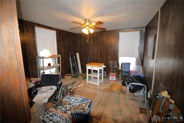 misc room with ceiling fan and wood walls