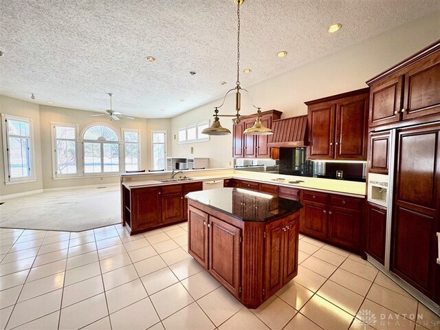 kitchen with light tile patterned flooring, premium range hood, pendant lighting, sink, and kitchen peninsula