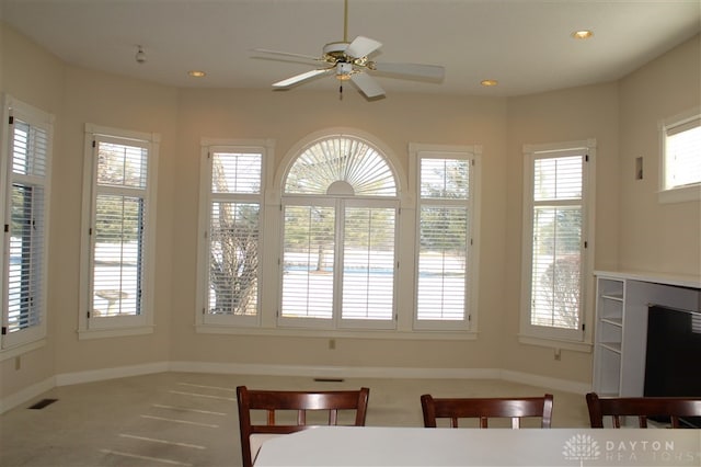 unfurnished dining area featuring ceiling fan and carpet flooring