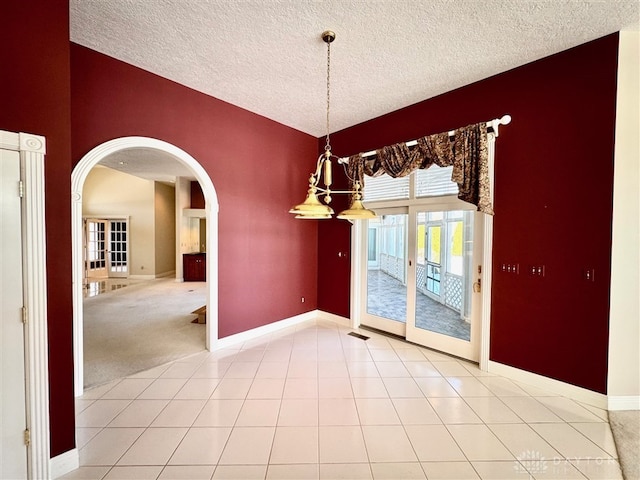 unfurnished dining area featuring tile patterned floors and a textured ceiling