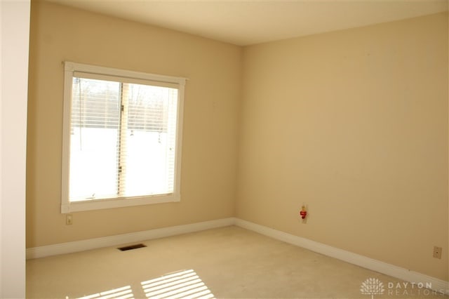 unfurnished room featuring light carpet