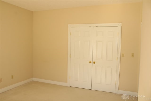 unfurnished bedroom with carpet floors and a closet