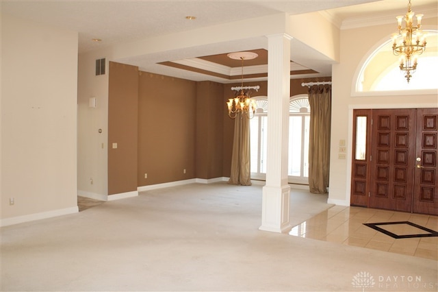 foyer entrance with ornate columns, crown molding, and a chandelier