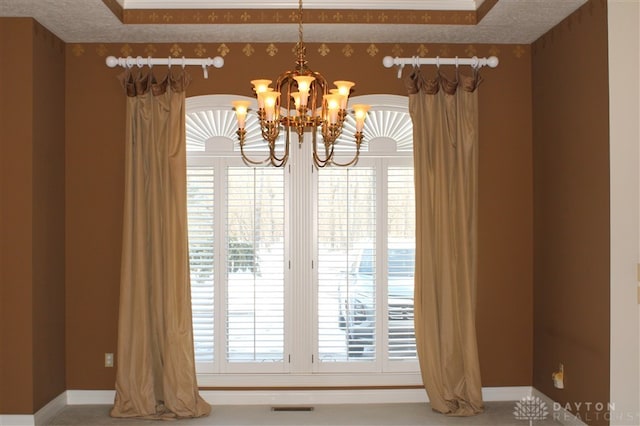 details with a textured ceiling and a chandelier