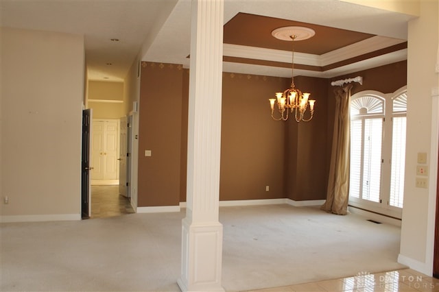 empty room featuring decorative columns, a chandelier, carpet, a tray ceiling, and crown molding