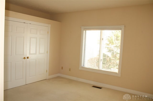 unfurnished bedroom with carpet and a closet