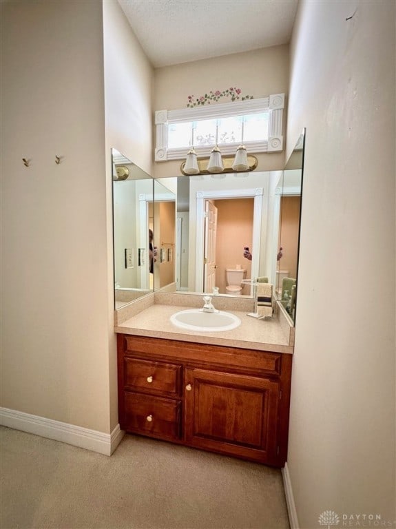 bathroom with vanity, a textured ceiling, toilet, and a high ceiling