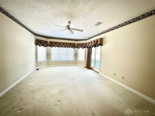 carpeted empty room featuring ceiling fan and a textured ceiling