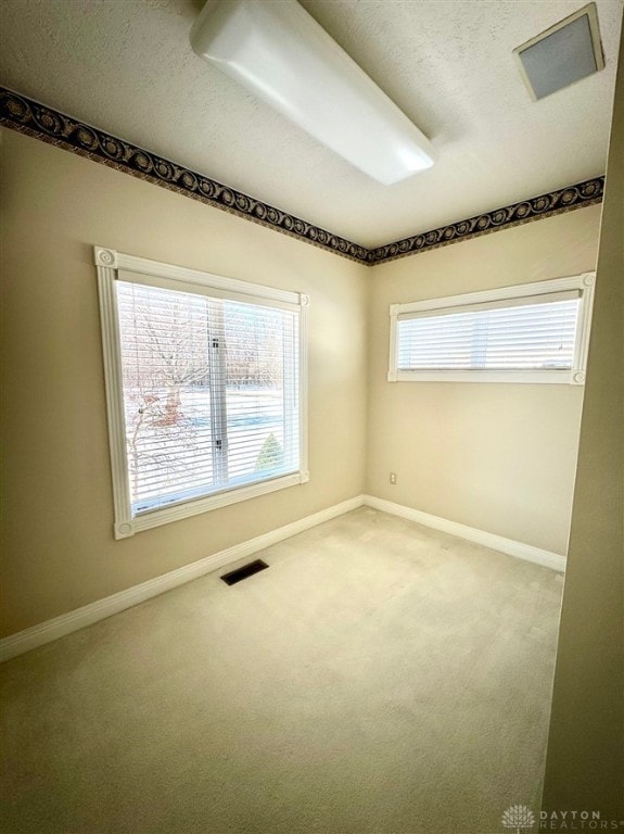 unfurnished room with carpet floors and a textured ceiling