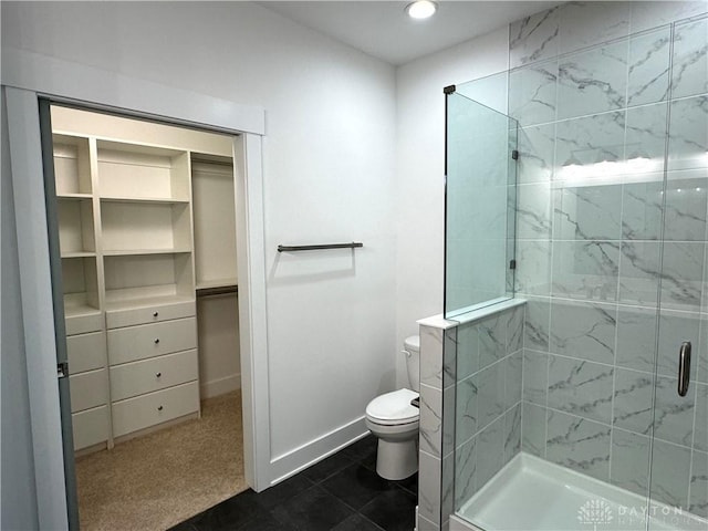 bathroom with toilet and a shower with door