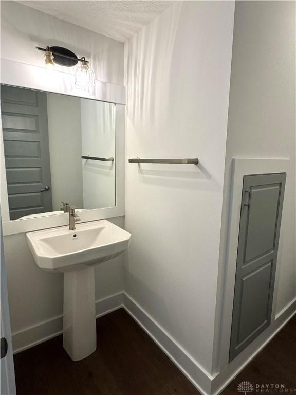 bathroom with wood-type flooring and a textured ceiling