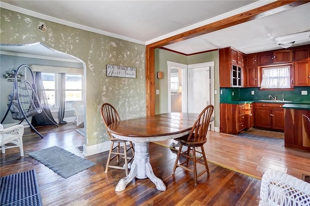 dining area with dark wood-type flooring and ornamental molding