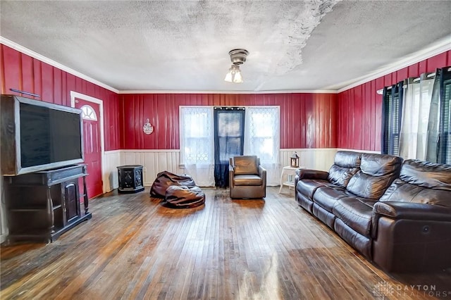 living room with a textured ceiling, ornamental molding, a wood stove, and dark hardwood / wood-style floors