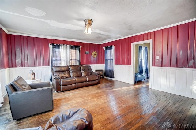 living room featuring hardwood / wood-style flooring, a textured ceiling, and crown molding