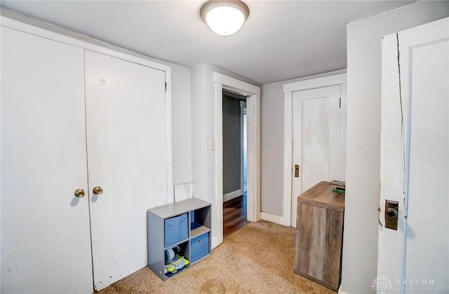 hallway featuring light colored carpet