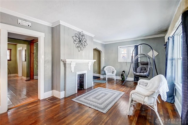 living area with a fireplace, dark hardwood / wood-style floors, and crown molding