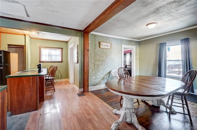 dining room featuring crown molding, a textured ceiling, and hardwood / wood-style floors