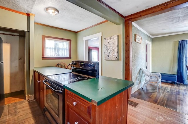 kitchen featuring electric stove, a textured ceiling, light hardwood / wood-style flooring, and crown molding