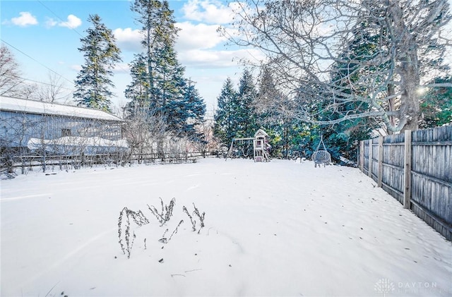 yard layered in snow with a playground