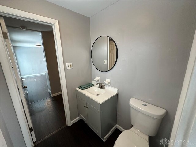 bathroom with hardwood / wood-style floors, toilet, and vanity