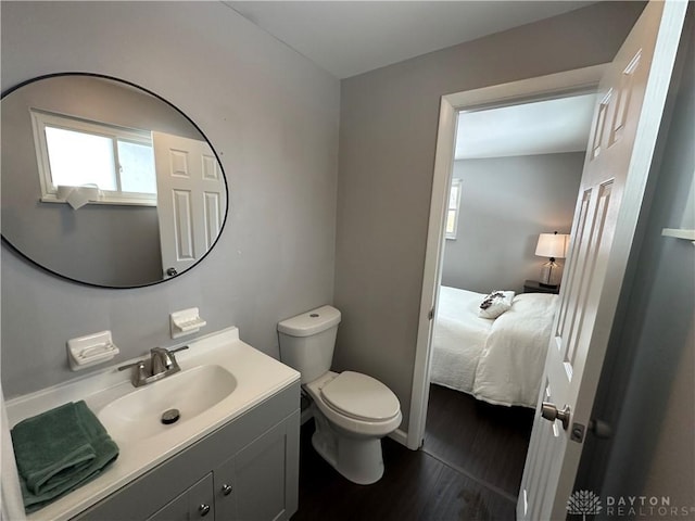 bathroom with toilet, vanity, and hardwood / wood-style floors