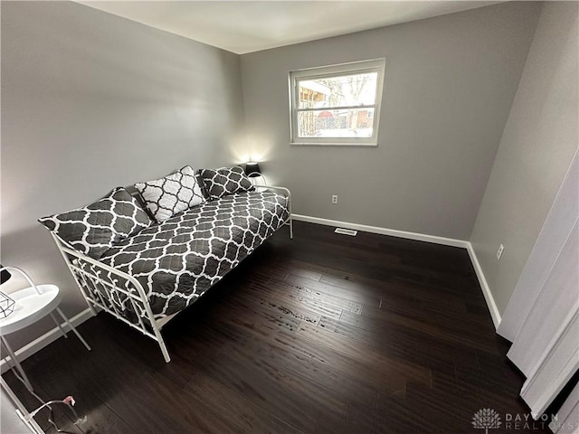 bedroom with dark wood-type flooring