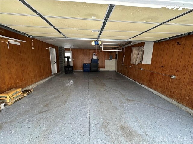 garage with a garage door opener and wood walls