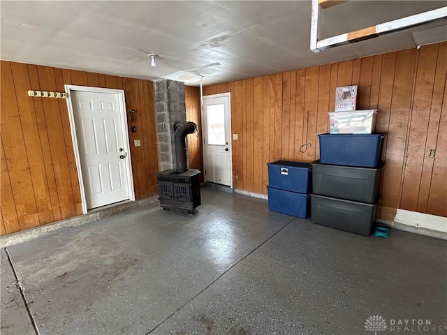 garage with a wood stove and wooden walls