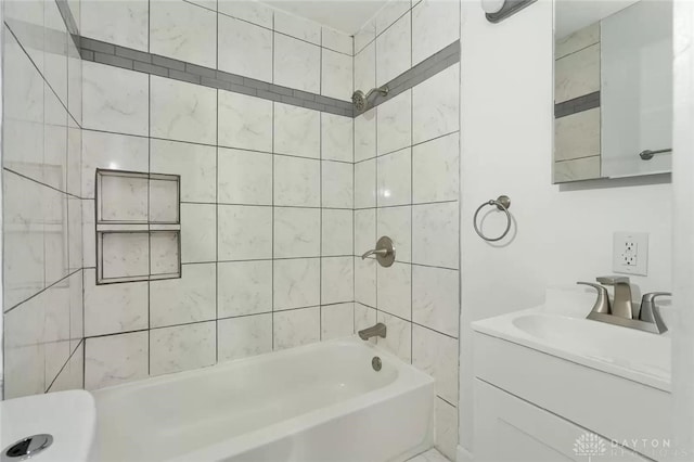 bathroom with tiled shower / bath combo and vanity