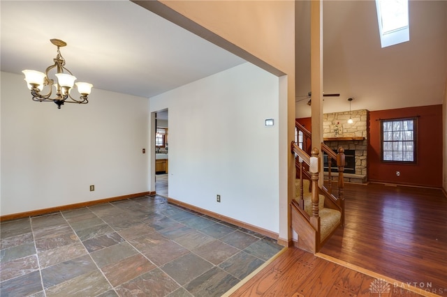 empty room featuring a skylight, a chandelier, and a fireplace