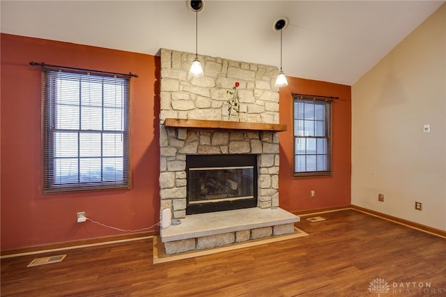 unfurnished living room featuring vaulted ceiling, a fireplace, and hardwood / wood-style floors