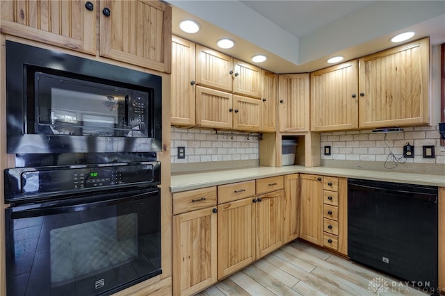 kitchen featuring decorative backsplash, light brown cabinetry, light hardwood / wood-style flooring, and black appliances