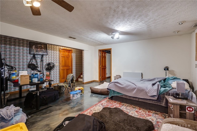 bedroom with a textured ceiling, ceiling fan, and concrete floors