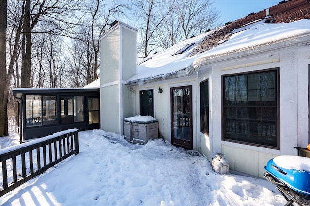 snow covered deck with a sunroom