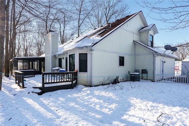 snow covered rear of property featuring central air condition unit