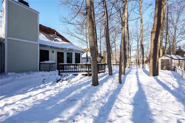 yard covered in snow featuring a deck