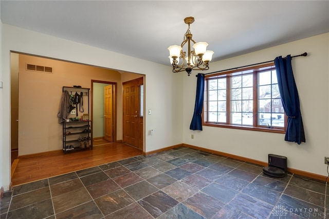 unfurnished room with a notable chandelier