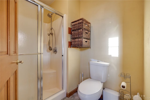 bathroom featuring an enclosed shower and toilet