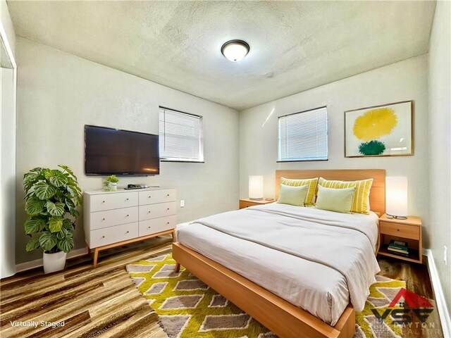 bedroom with hardwood / wood-style floors and a textured ceiling