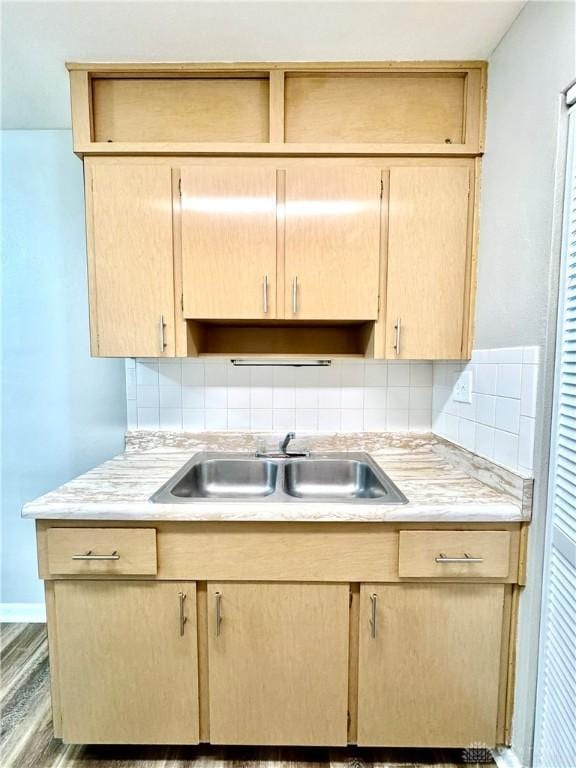 kitchen featuring light brown cabinets, light countertops, and a sink