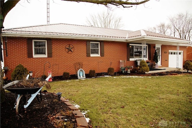 rear view of house with a garage and a yard