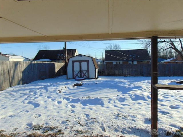 snowy yard with a storage shed