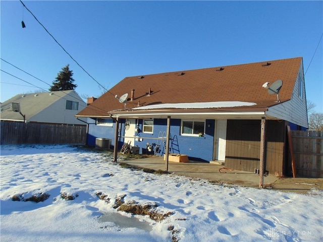 snow covered house featuring a patio area and central air condition unit